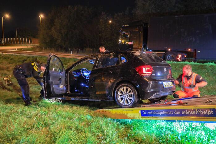 Auto belandt op z'n kop naast snelweg