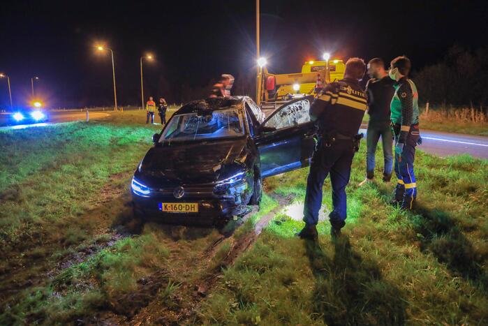 Auto belandt op z'n kop naast snelweg
