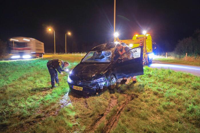 Auto belandt op z'n kop naast snelweg