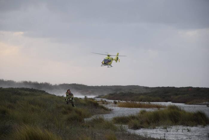 Persoon gered van zandbank door helikopter