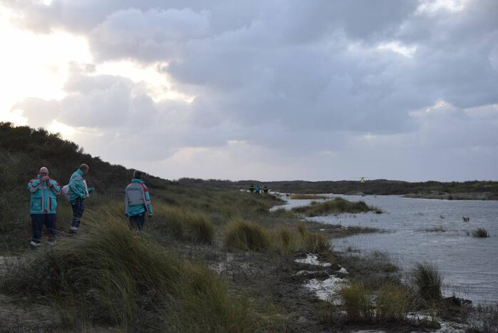 Persoon gered van zandbank door helikopter