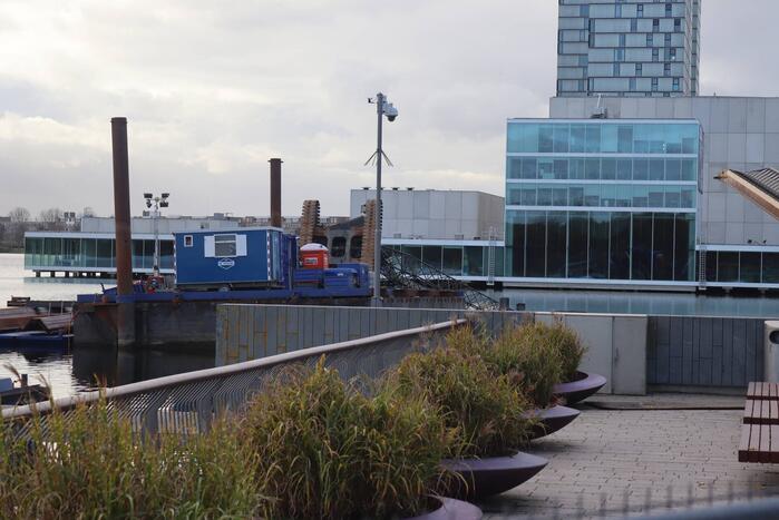 Hijskraan op ponton valt in water