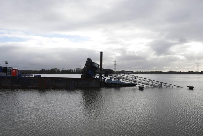 Hijskraan op ponton valt in water