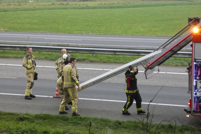 Brandweer blust brand naast snelweg