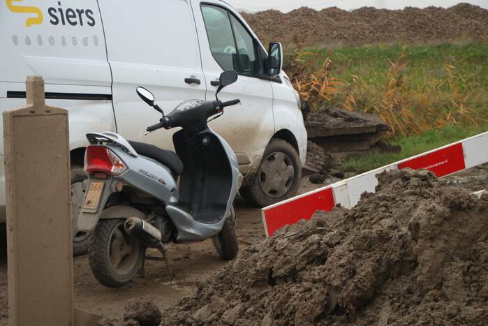Brommerrijdster gaat onderuit op weg met modder bedekt