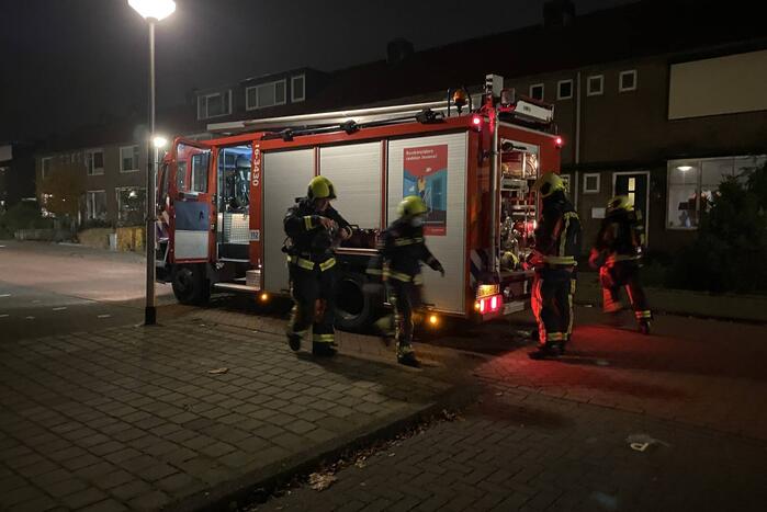 Brandweer blust brandende hoop kranten op schoolplein