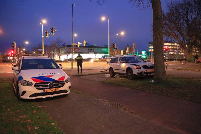 Automobilist rijdt paal omver en botst tegen boom