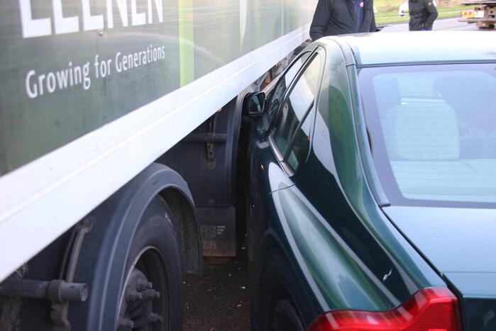 Vrachtwagen en auto botsen op rotonde