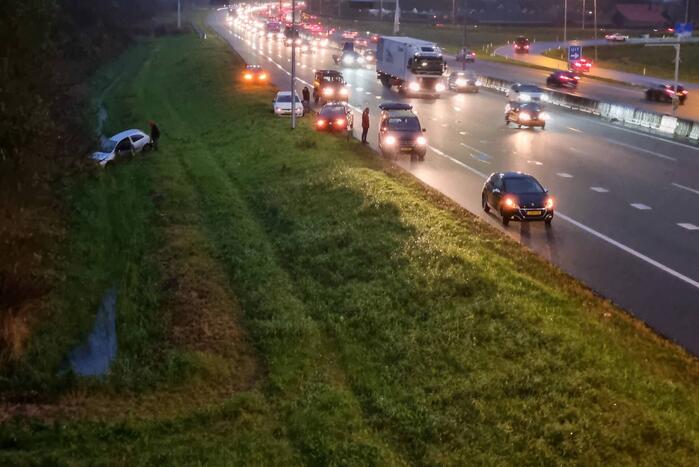 Auto belandt in sloot naast snelweg