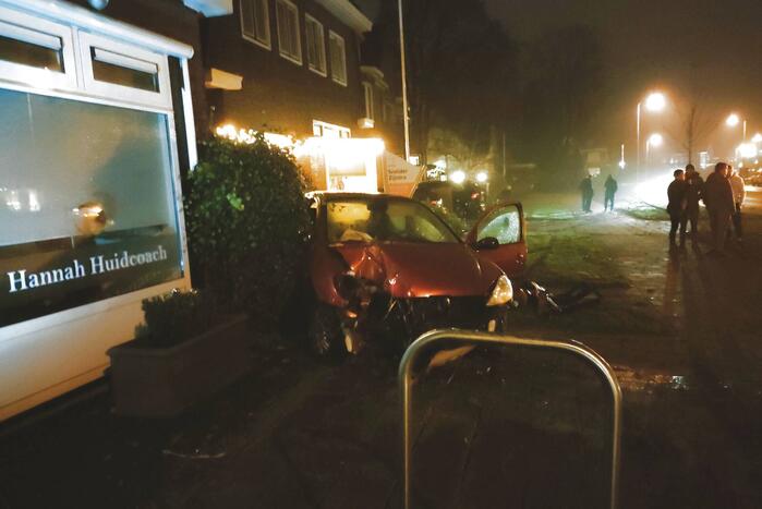 Auto zwaar beschadigd na botsing tegen gebouw