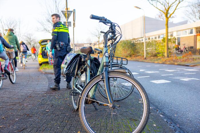 Scholier en vrouw botsen tijdens het fietsen op elkaar