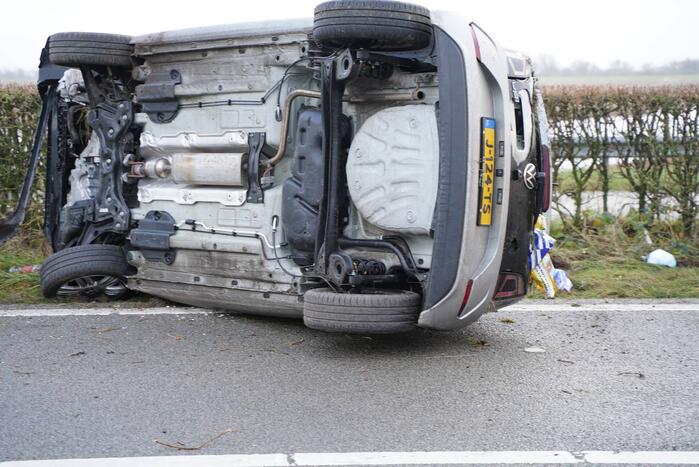 Auto op zijn kant bij verkeersongeval