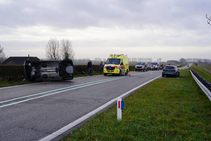 Auto op zijn kant bij verkeersongeval