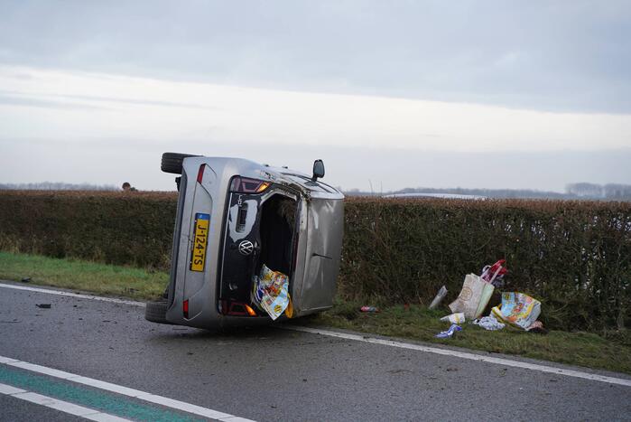 Auto op zijn kant bij verkeersongeval