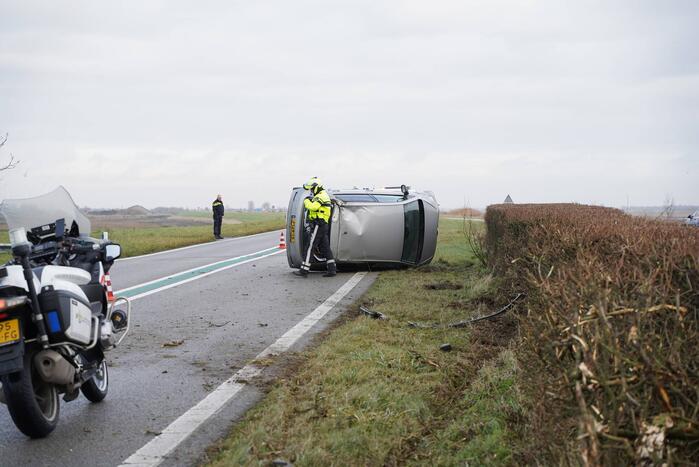 Auto op zijn kant bij verkeersongeval