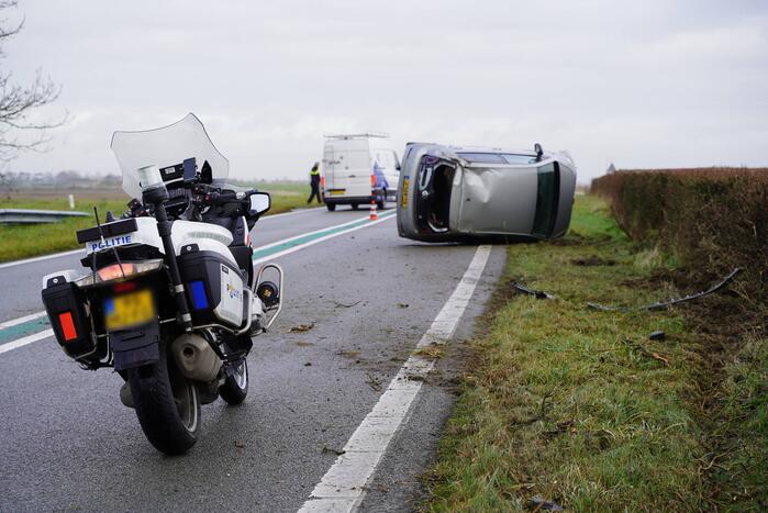 Auto op zijn kant bij verkeersongeval