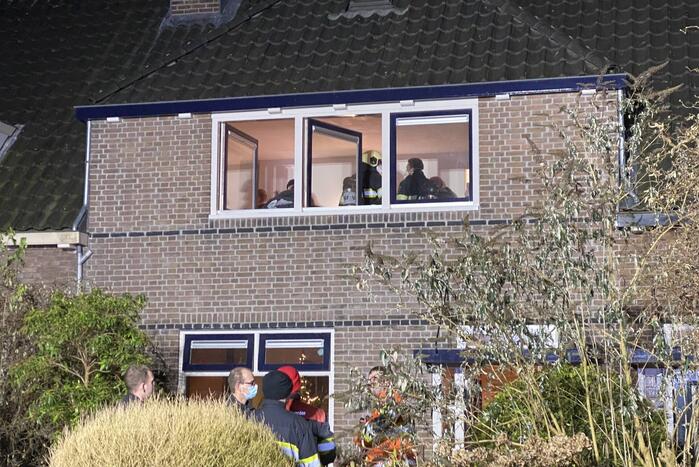 Brandweer breekt schoorsteen open na brandlucht