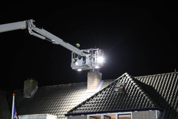 Brandweer breekt schoorsteen open na brandlucht