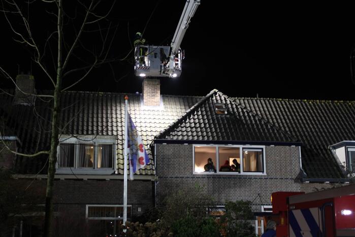 Brandweer breekt schoorsteen open na brandlucht