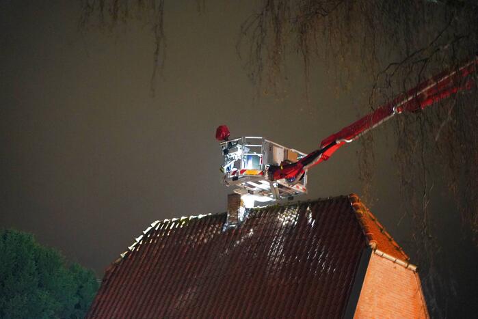Brandweer veegt schoorsteen na brand