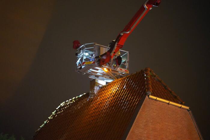 Brandweer veegt schoorsteen na brand