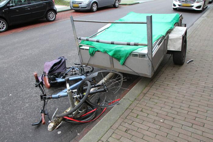 Aanhanger schiet los van auto en schept fietser