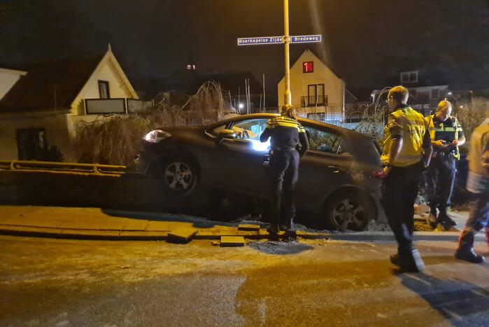 Auto belandt op betonnen muur van de brug