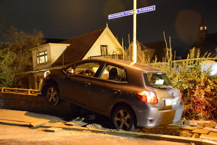 Auto belandt op betonnen muur van de brug