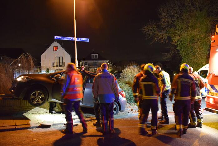 Auto belandt op betonnen muur van de brug