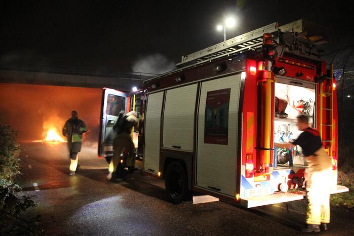 Stapel afval in brand onder brug over snelweg