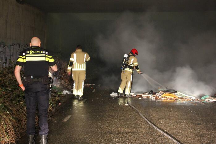Stapel afval in brand onder brug over snelweg