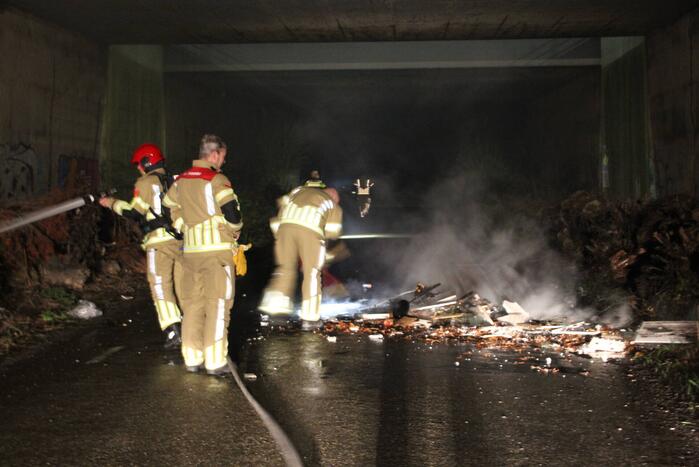 Stapel afval in brand onder brug over snelweg