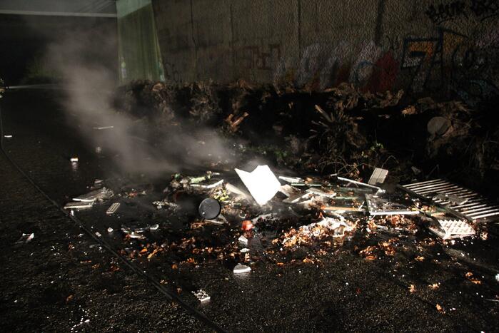 Stapel afval in brand onder brug over snelweg