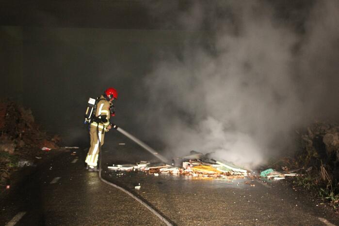 Stapel afval in brand onder brug over snelweg