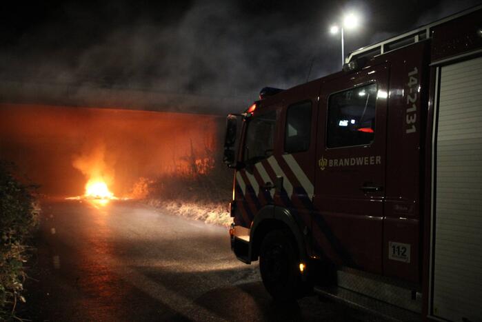 Stapel afval in brand onder brug over snelweg