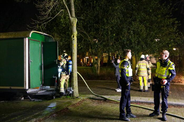 Brandweer blust brand in bouwkeet