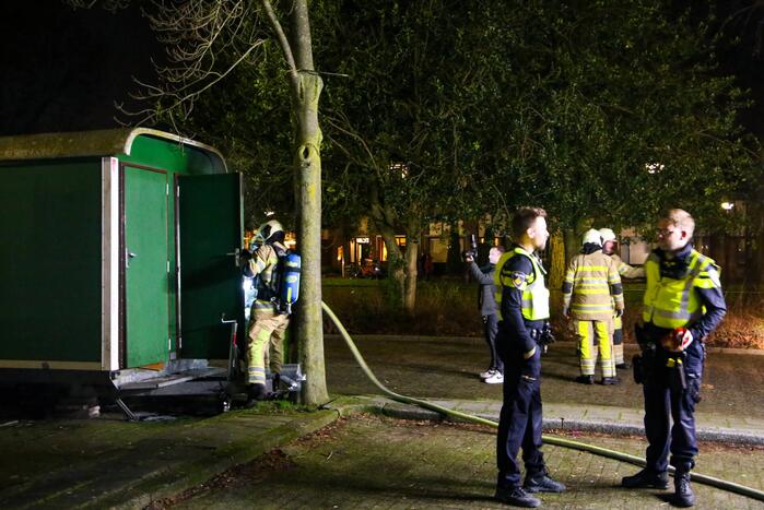 Brandweer blust brand in bouwkeet