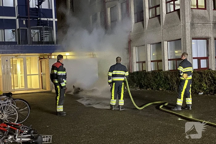 Container in brand tegen gebouw