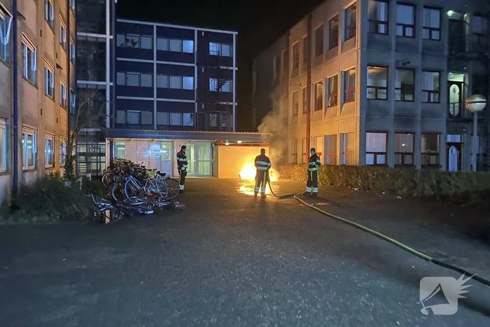 Container in brand tegen gebouw
