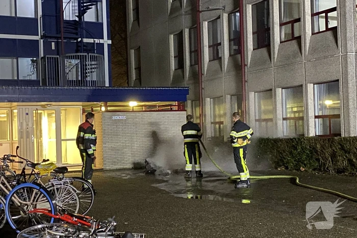 Container in brand tegen gebouw
