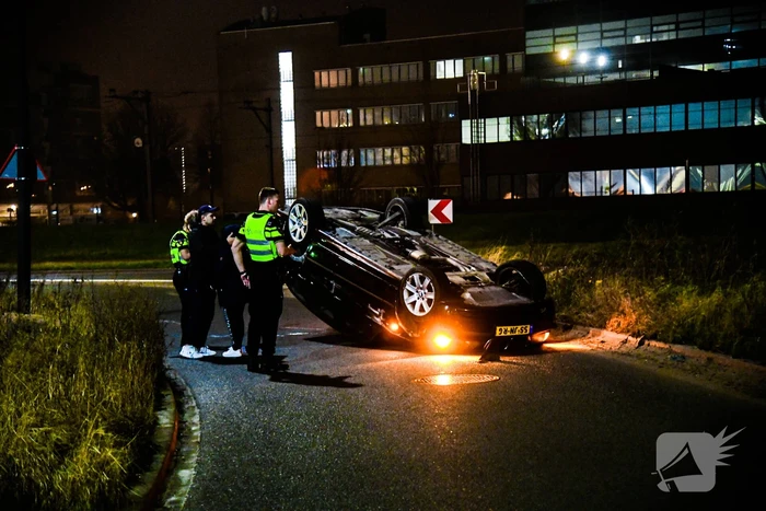 Auto vliegt uit de bocht en belandt op op zijn kop