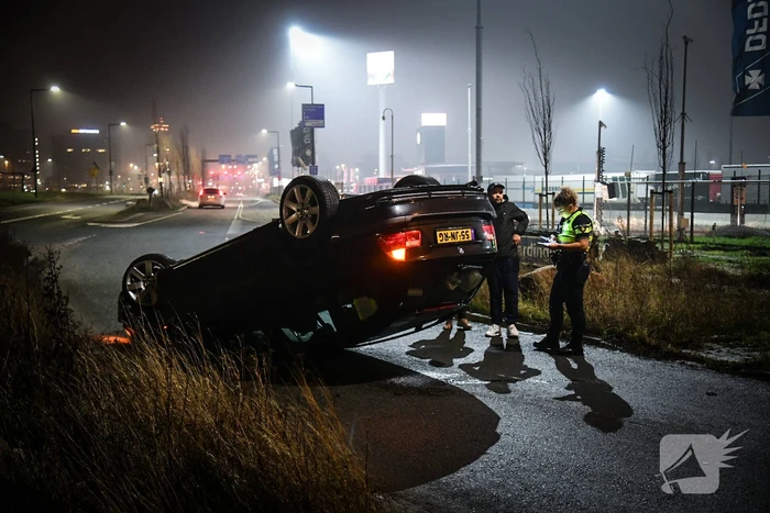Auto vliegt uit de bocht en belandt op op zijn kop