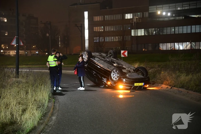 Auto vliegt uit de bocht en belandt op op zijn kop