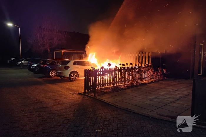 Auto en schutting in brand