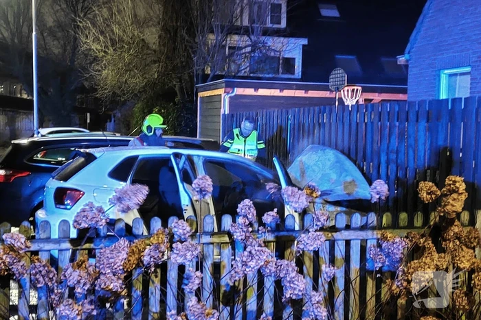 Auto en schutting in brand