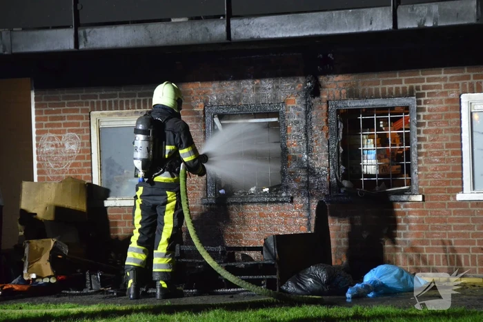 Bank in brand onder balkon van flat