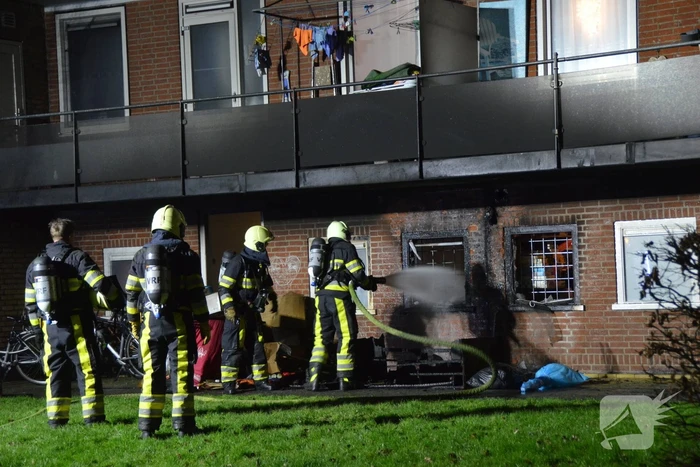 Bank in brand onder balkon van flat