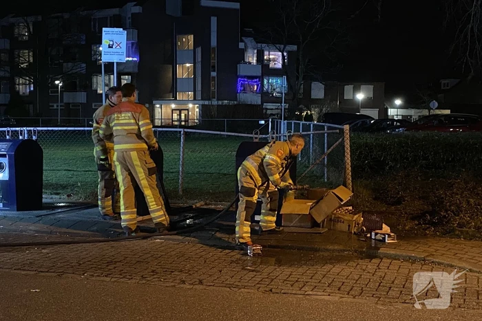 Oud papier tegen container in brand