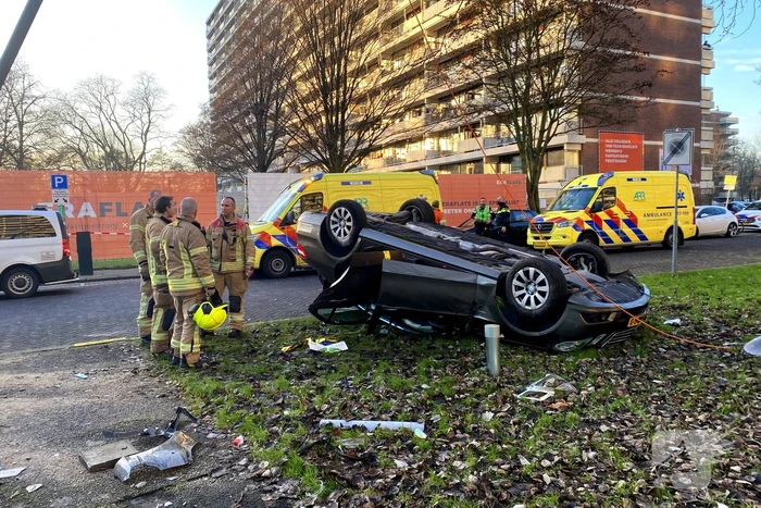 Auto ramt lantaarnpaal en slaat over de kop