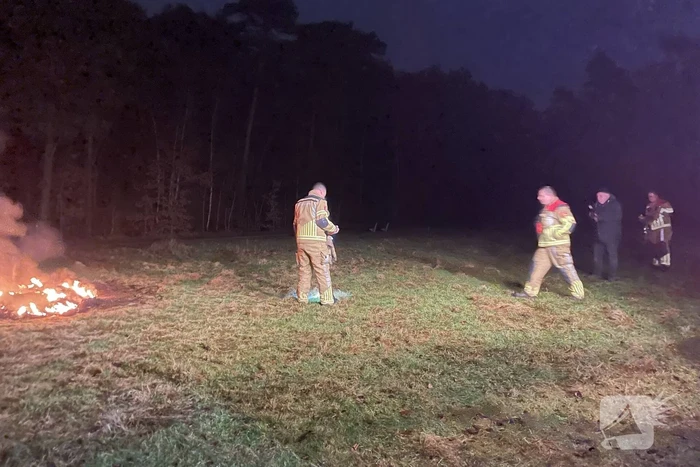 Brandweer blust brandende hoop afval